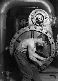 Bedrijfsverhaal: Historische zwart-wit foto van stoere monteur voor een machine